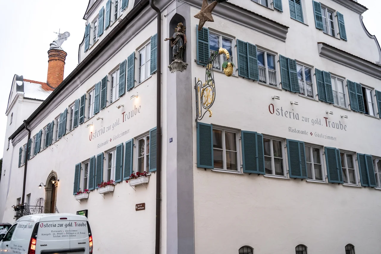Fassade der Osteria zur goldenen Traube mit grünen Fensterläden