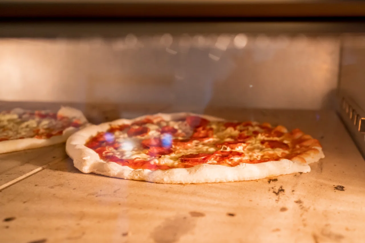 Pizza im warmen Licht des Ofens der Osteria